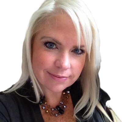 A woman with long, straight, platinum-blonde hair and blue eyes smiles softly. Dressed in a black top and a beaded necklace with gold and brown tones, she exudes the confidence of a CEO. The background is transparent.
